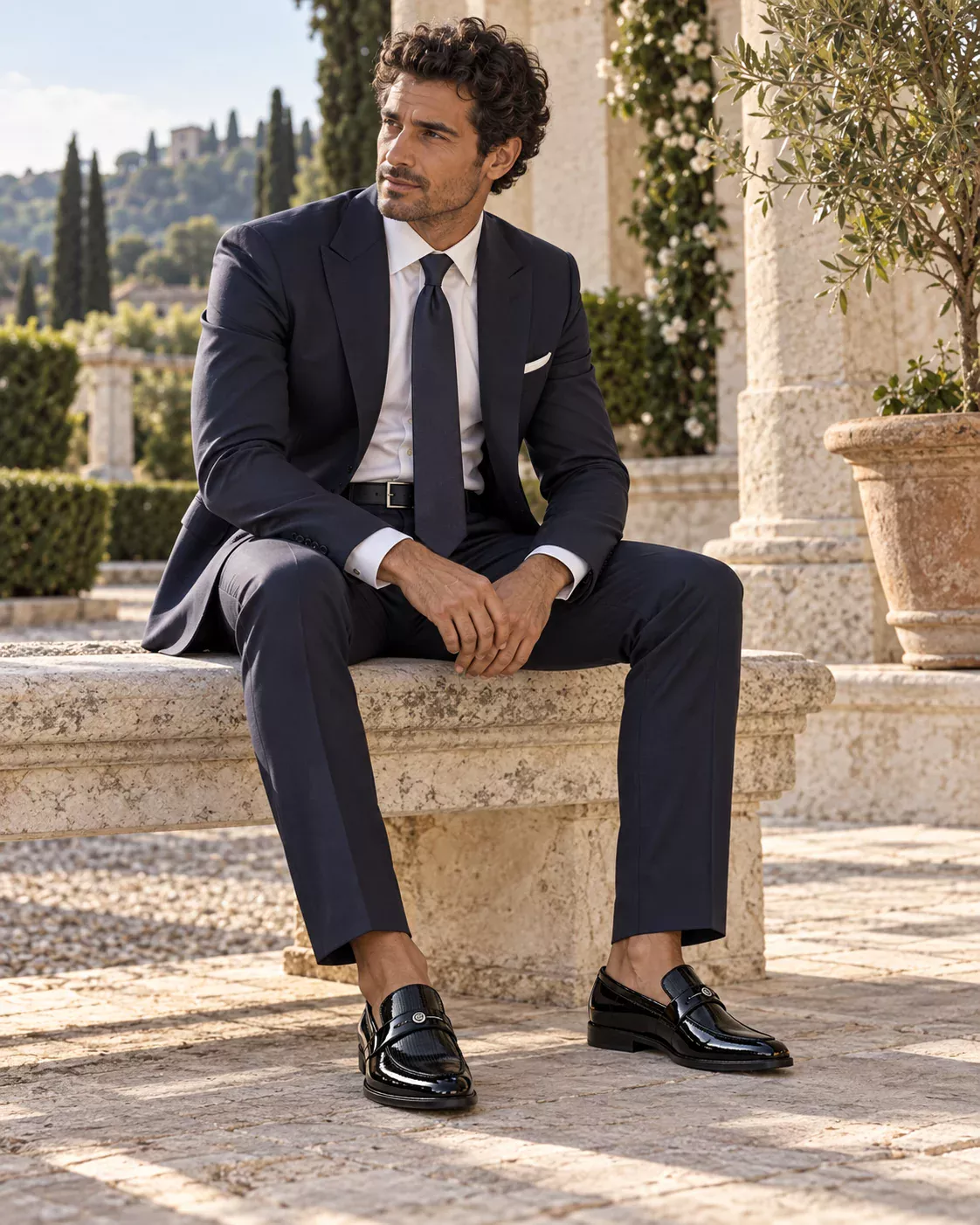 Indossatore virtuale seduto in terrazza, con abito blu, calzature e cintura coordinate O.M. LAB